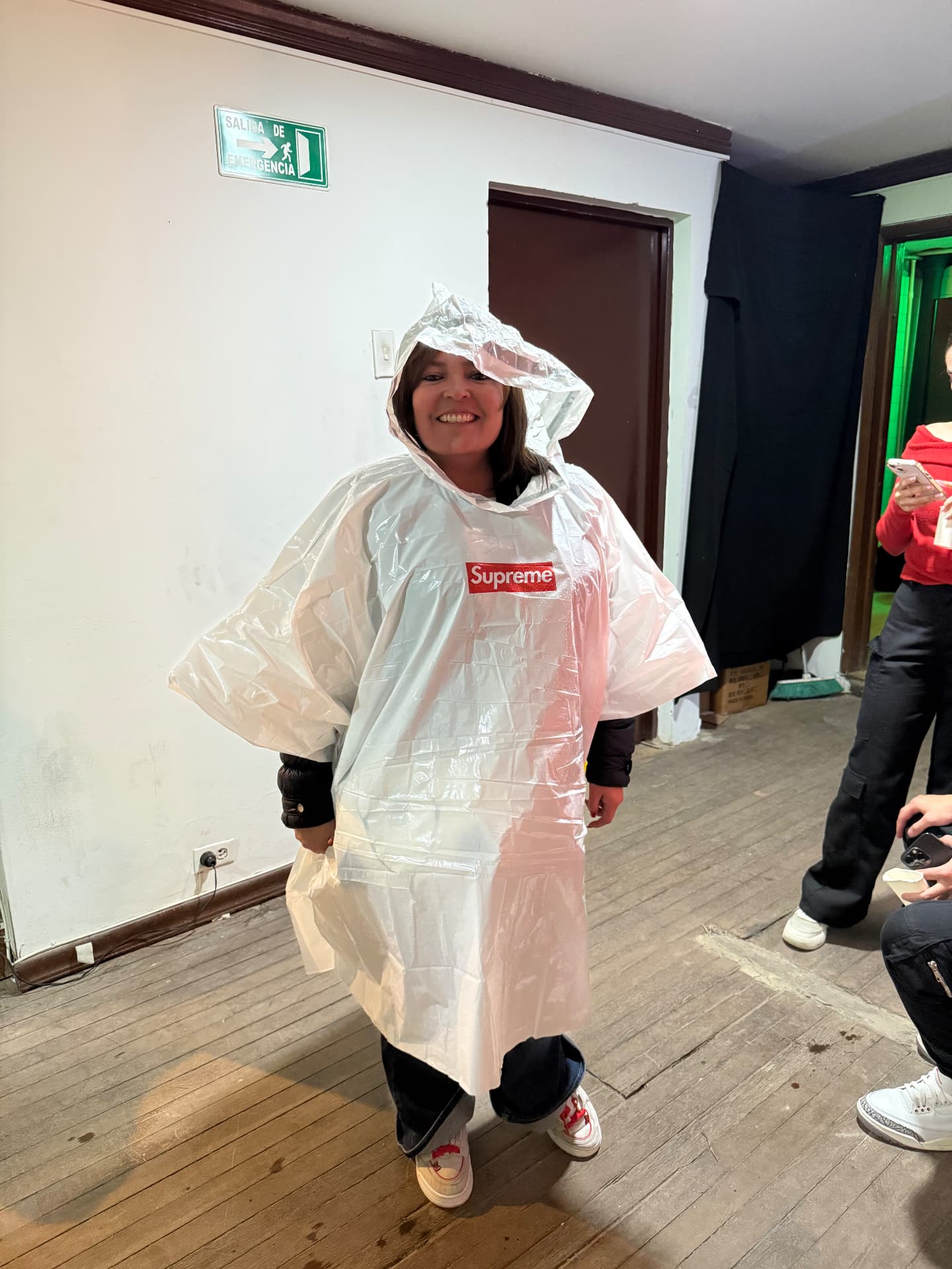 Smiling in a Supreme poncho at the event