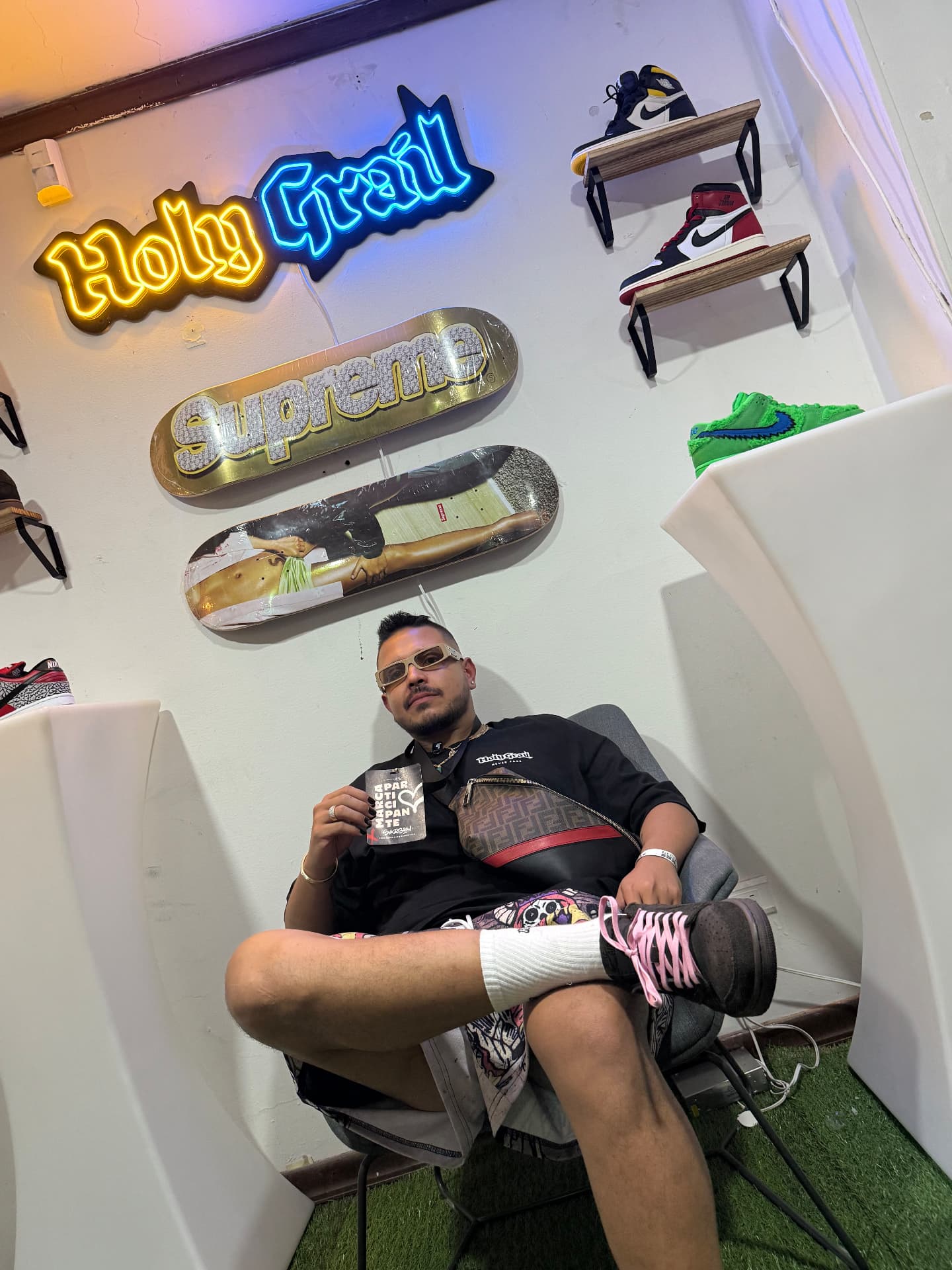 Holy Grail team seated under the Holy Grail neon sign