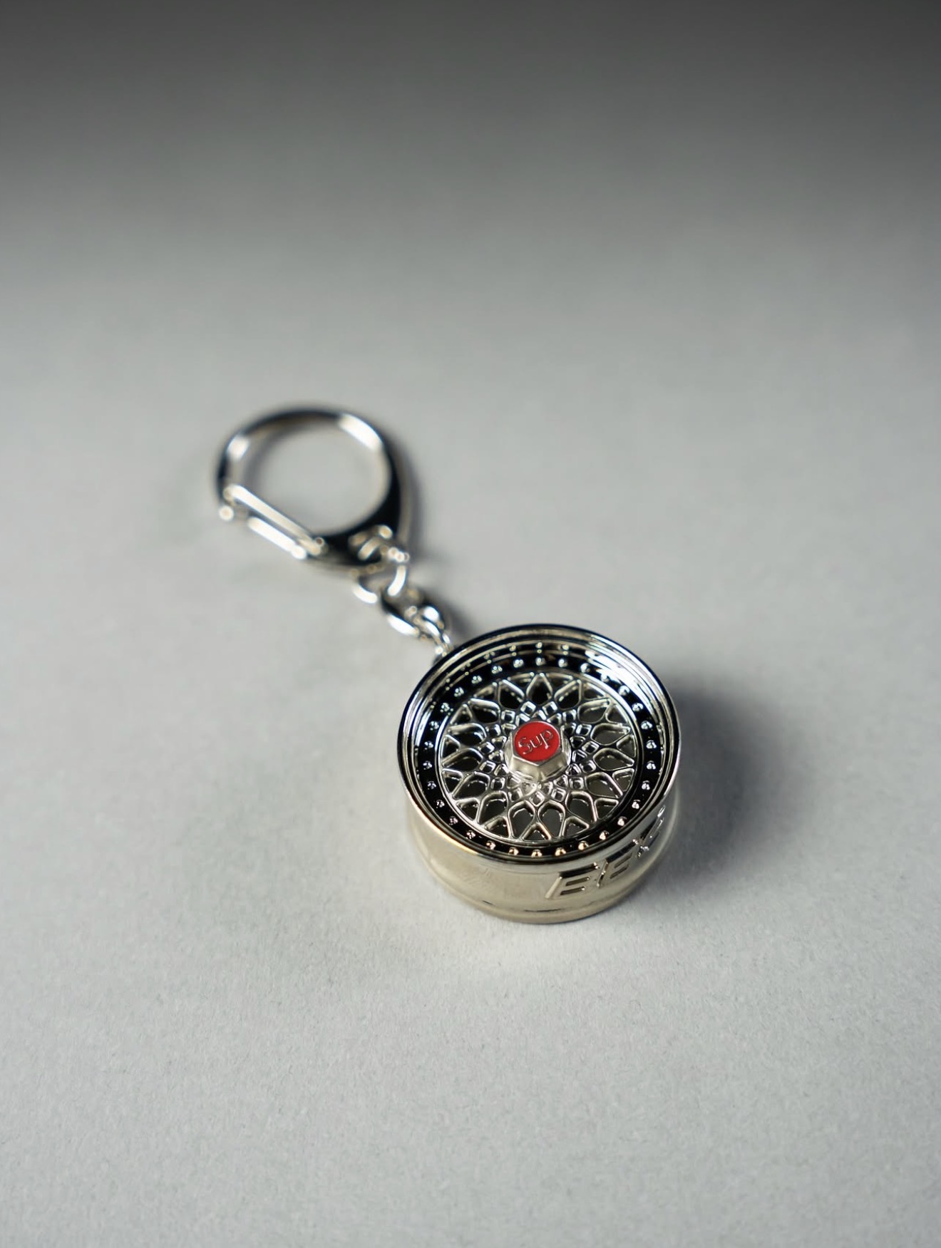 Chrome wheel keychain with a red enamel centre cap — Holy Grail