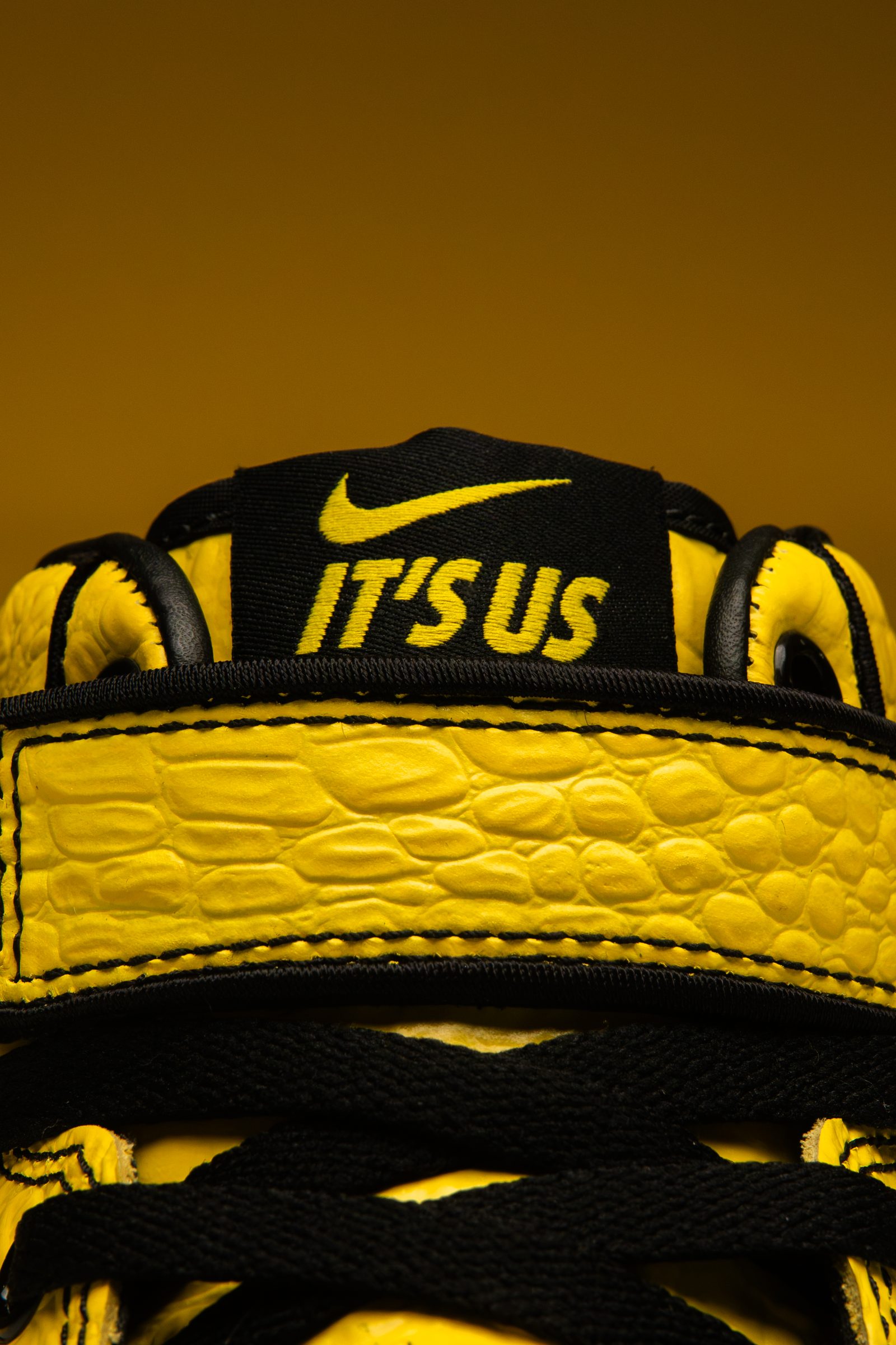 Detalle de la lengüeta del Nike Air Force 1 Mid x Lil Yachty Opti Yellow con el logo Nike y el bordado amarillo IT'S US.